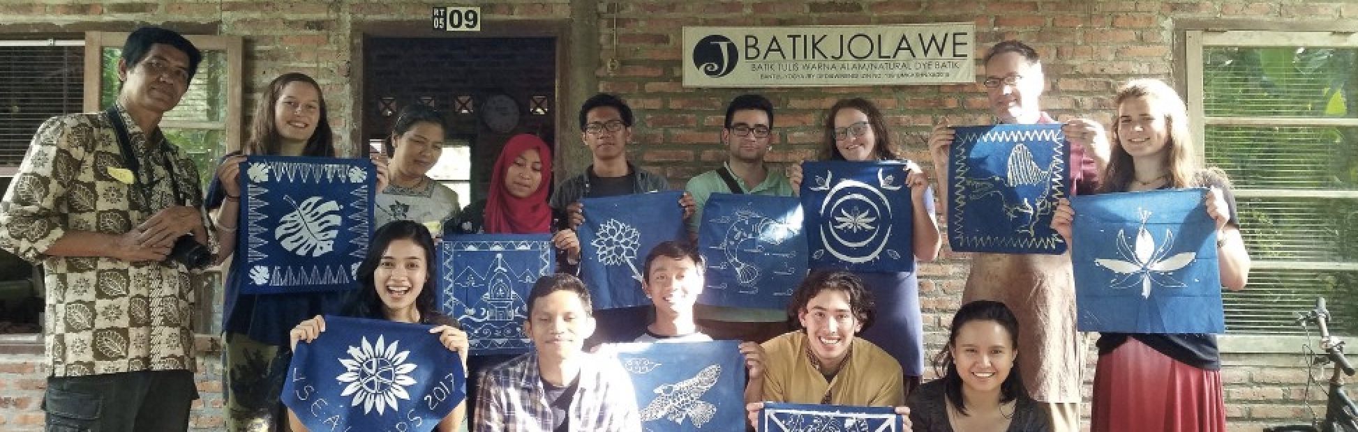 A group of people holding up Batik artwork