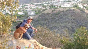 Student smiling next to a dog in a scenic picture