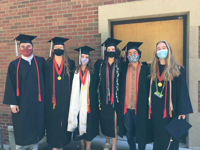 A group of graduates wearing gowns and face masks