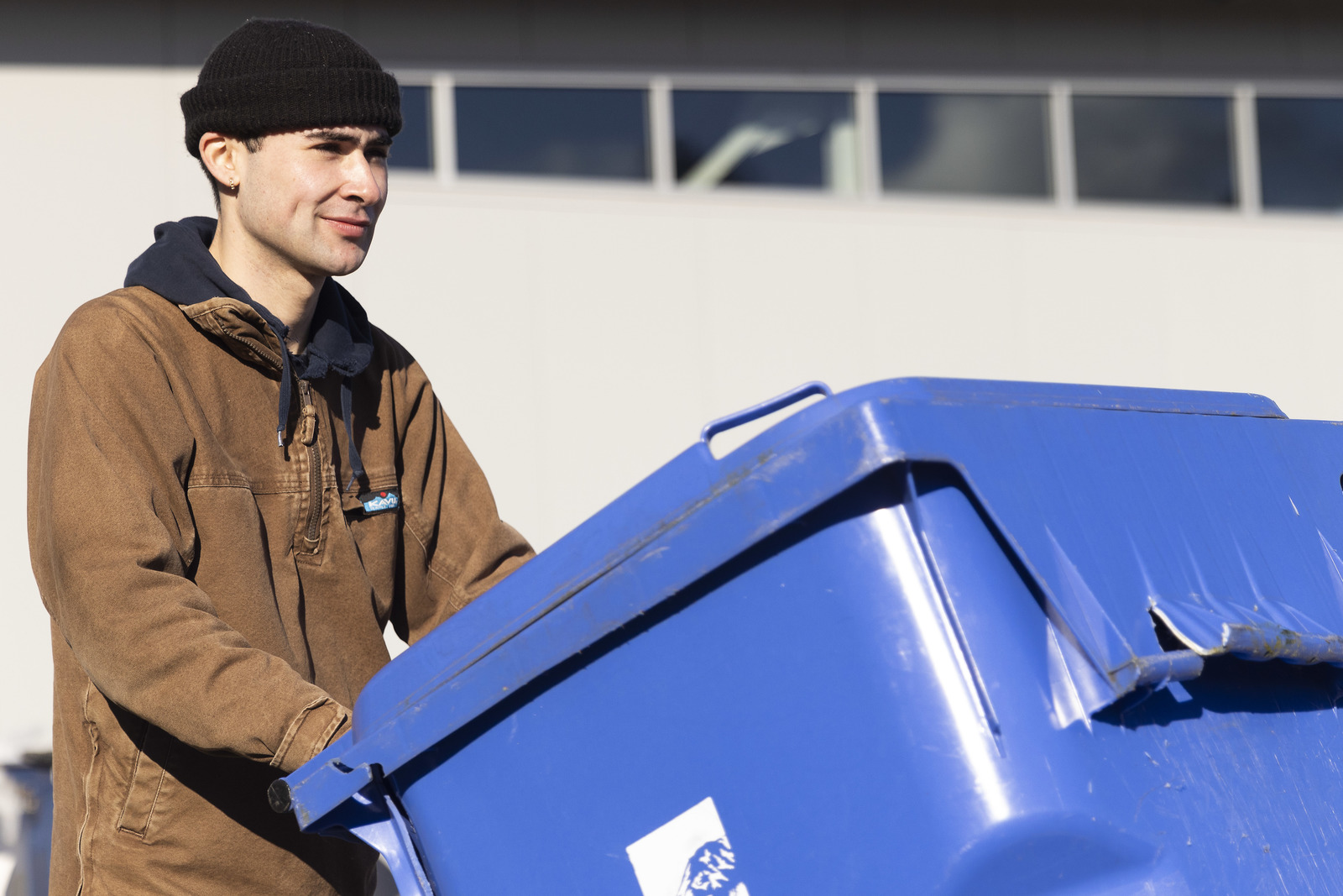 Alden Robert ’23 moves a blue recycling bin