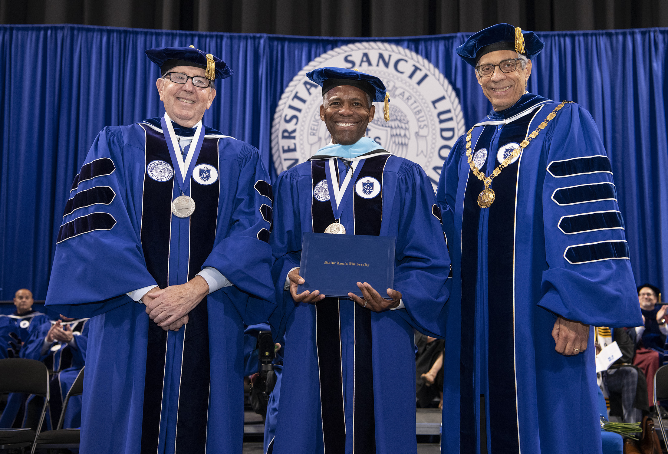 President Isiaah Crawford receives honorary degree, flanked by Joseph P. Conran (left) and Fred P. Pestello (right)