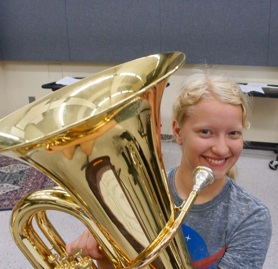 Smiling student holding an instrument