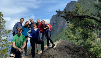 A group posing in front of a mountain vista