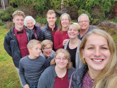 Ann Marie Trebon Henninger ’88 and Ray Henninger ’89, M.P.T.’91 show off their Logger maroon in this family photo with their seven children and Ann Marie’s 93-year-old mom, Marian Trebon P’88