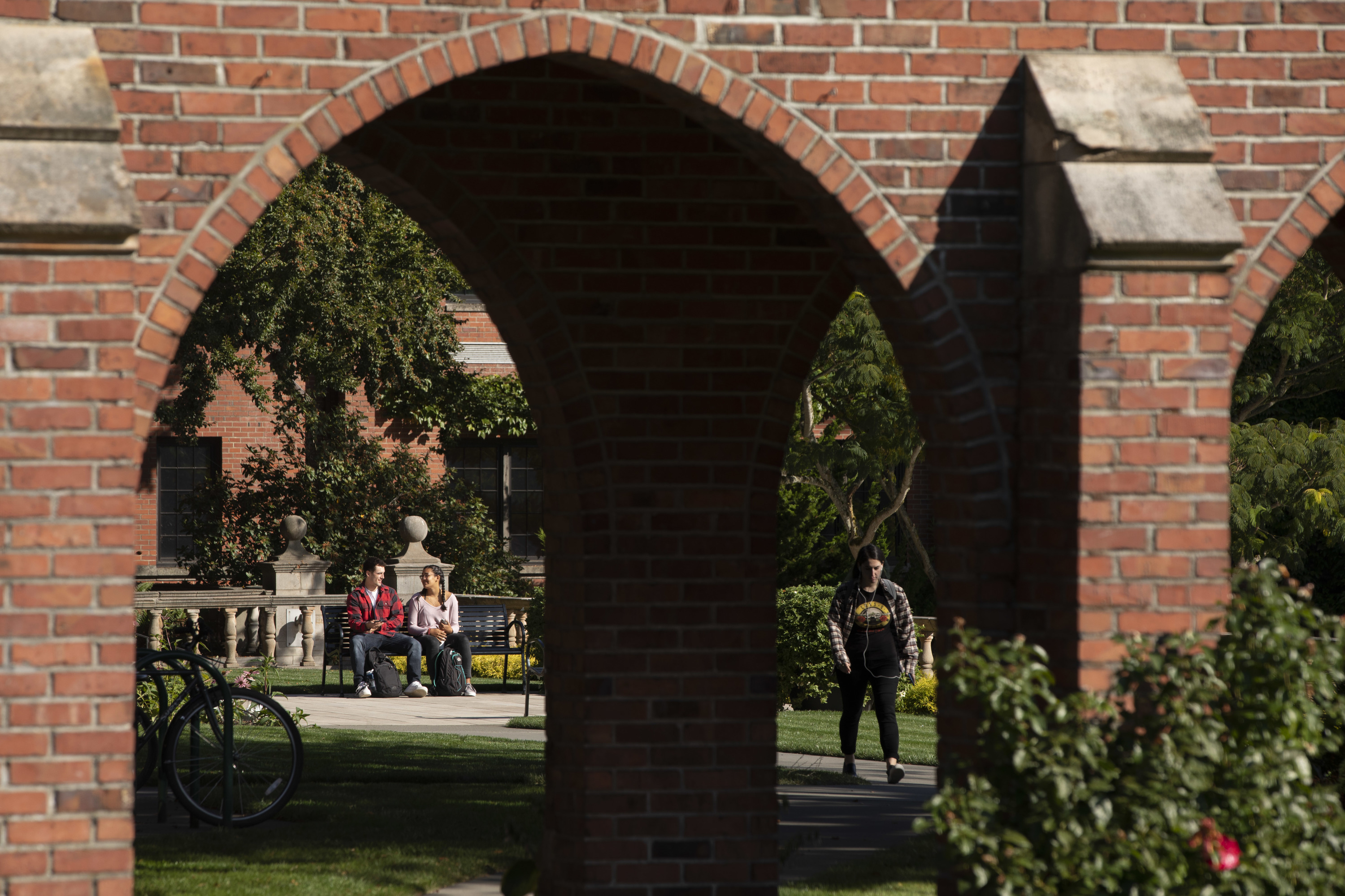 Students seen through the arches on campus.