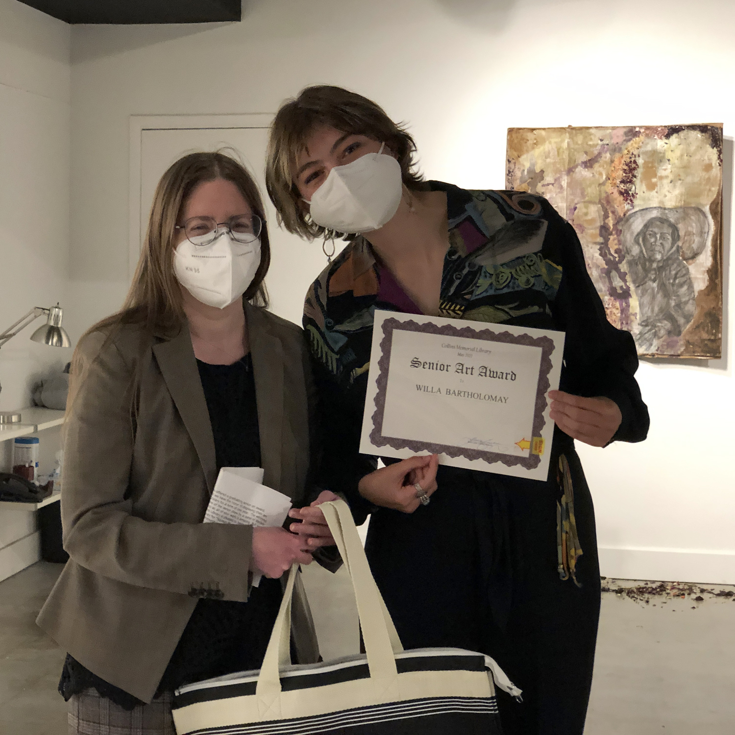 Two people in a gallery wearing face masks
