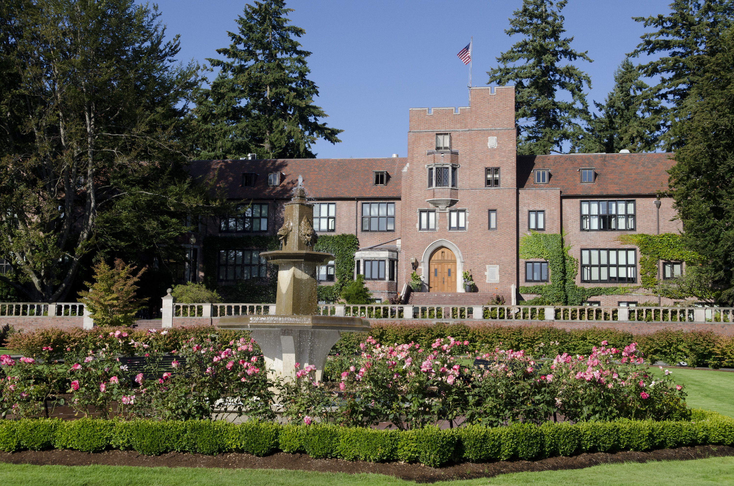 Jones Hall sits in behind a garden of flowers on campus. 