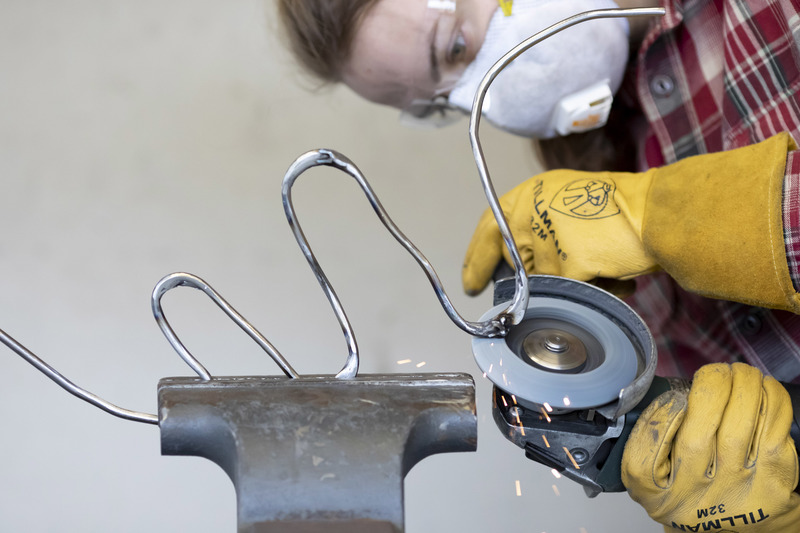 A person using power tools to craft a sculpture