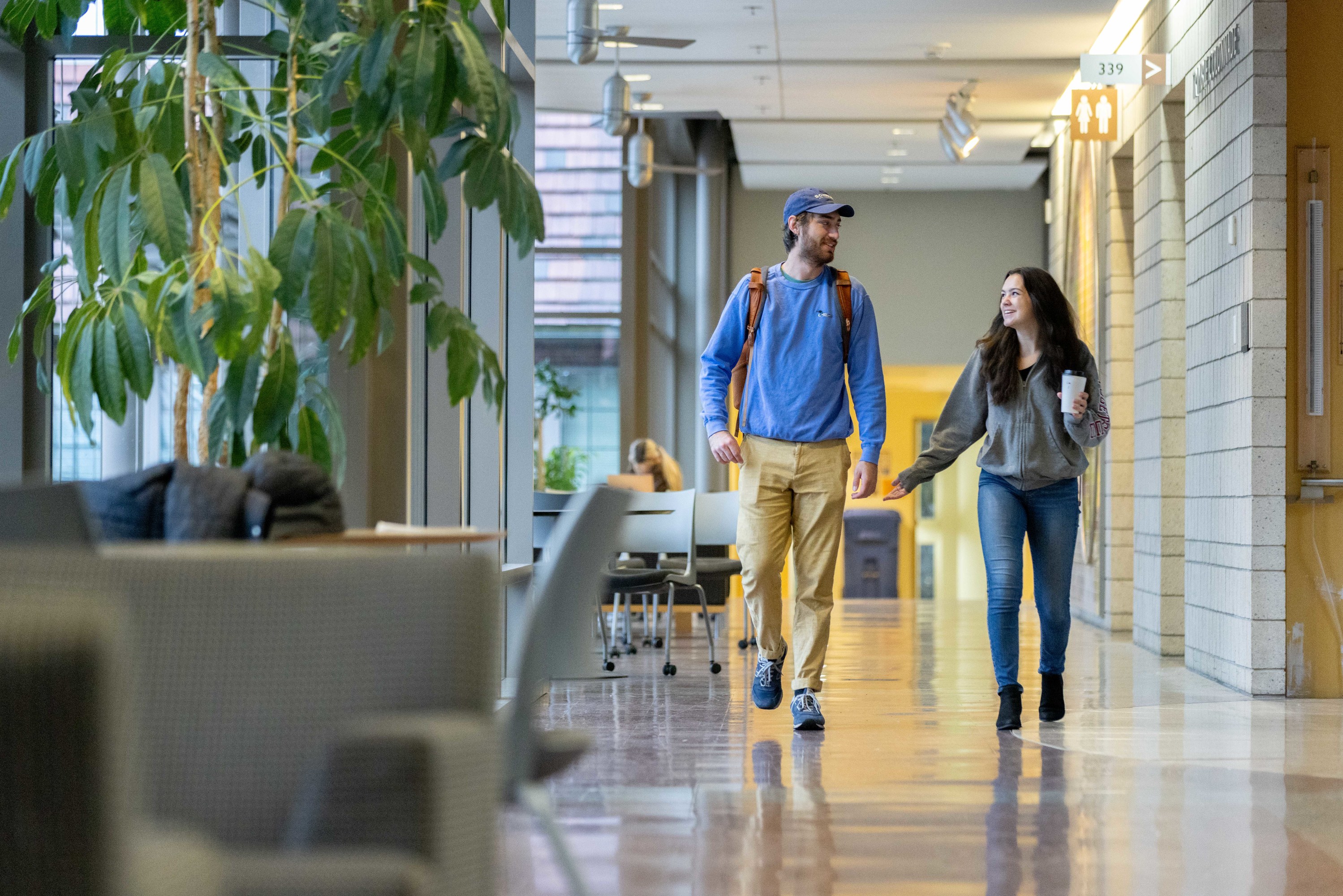 A peer advisor walks and chats with their advisee.