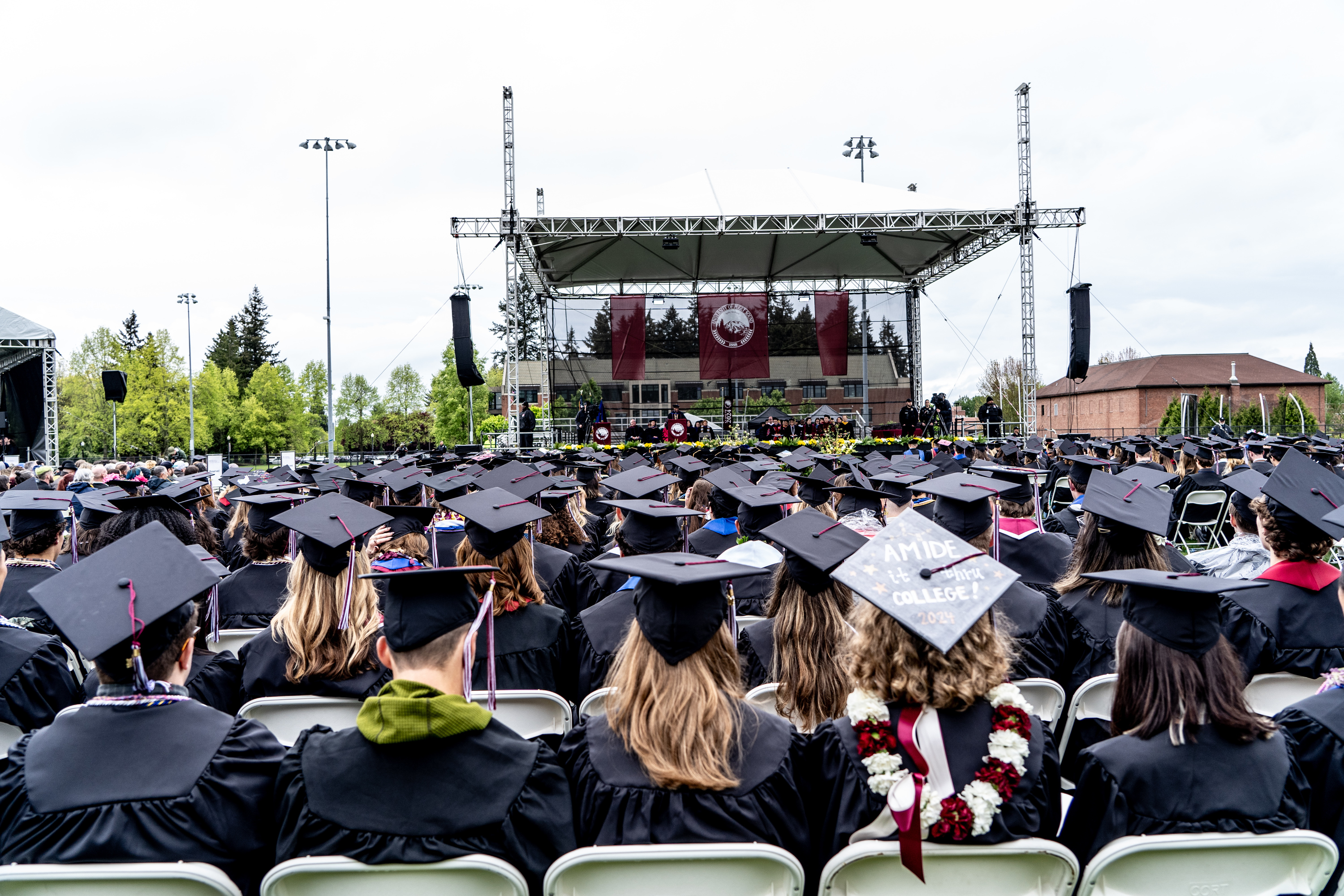 Graduates sit with their backs to the camera during a commencement ceremony. 