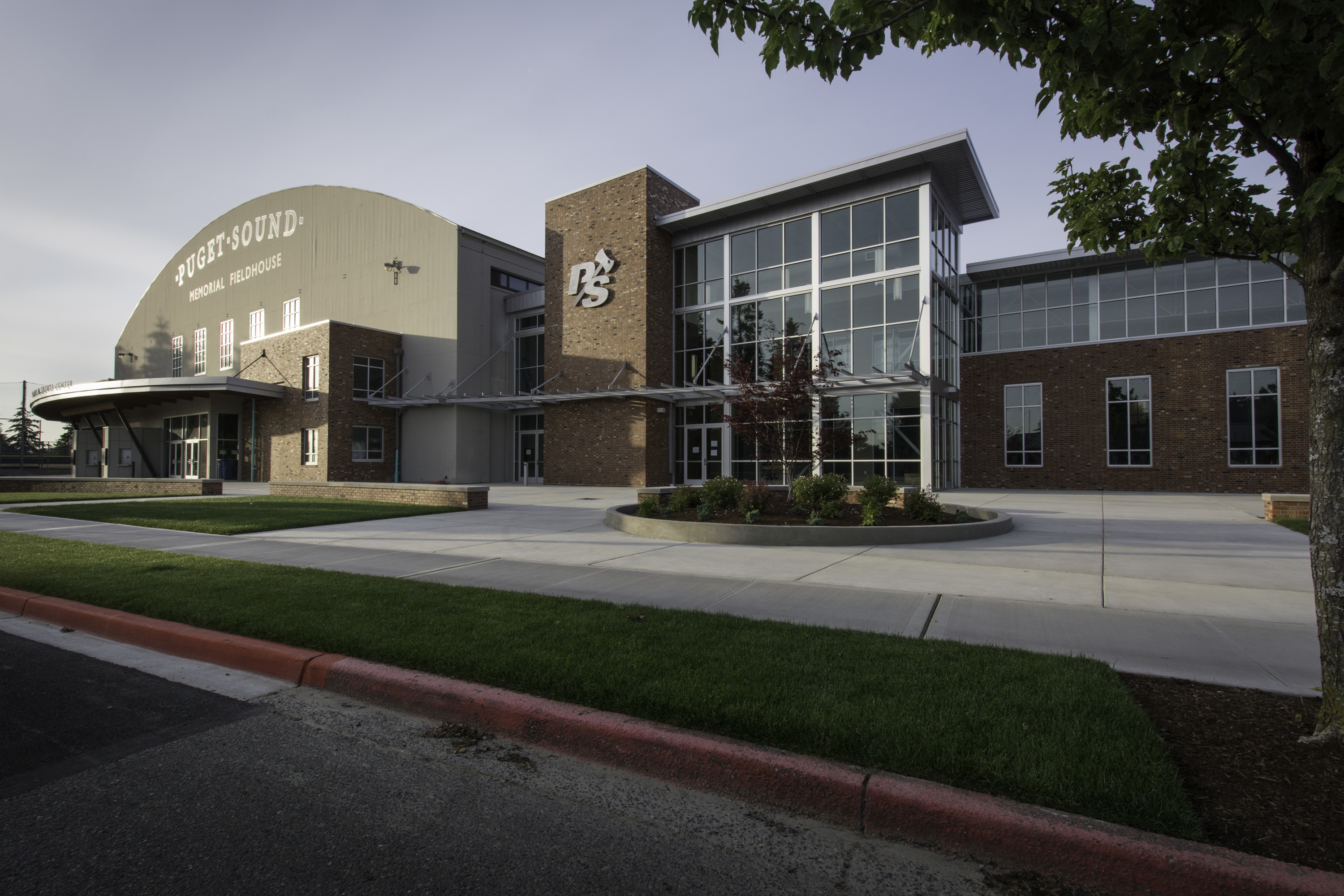 The exterior of Memorial Fieldhouse is seen with sun setting behind it. 