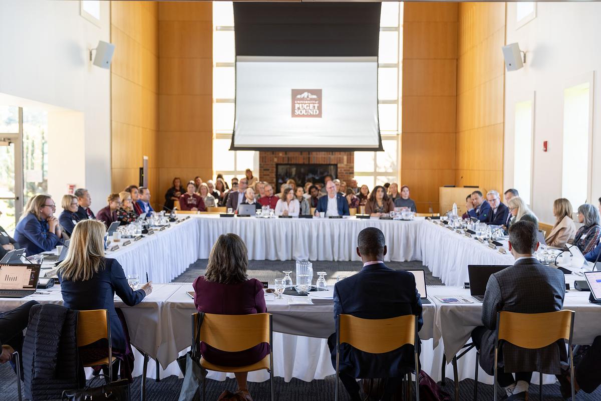 Trustees sit at tables in a circle. 