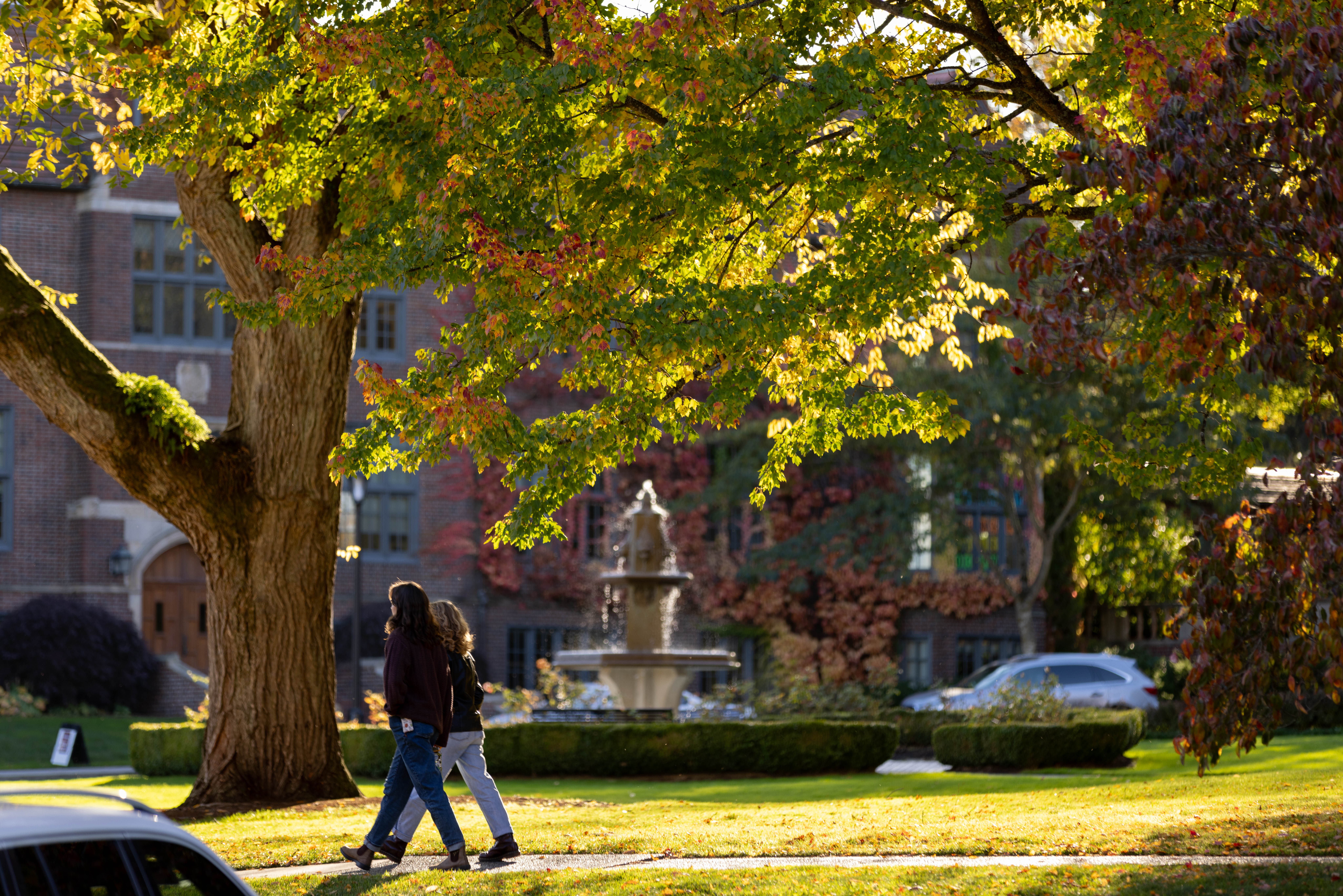 Two students walking near Jones fountain and Howarth Hall