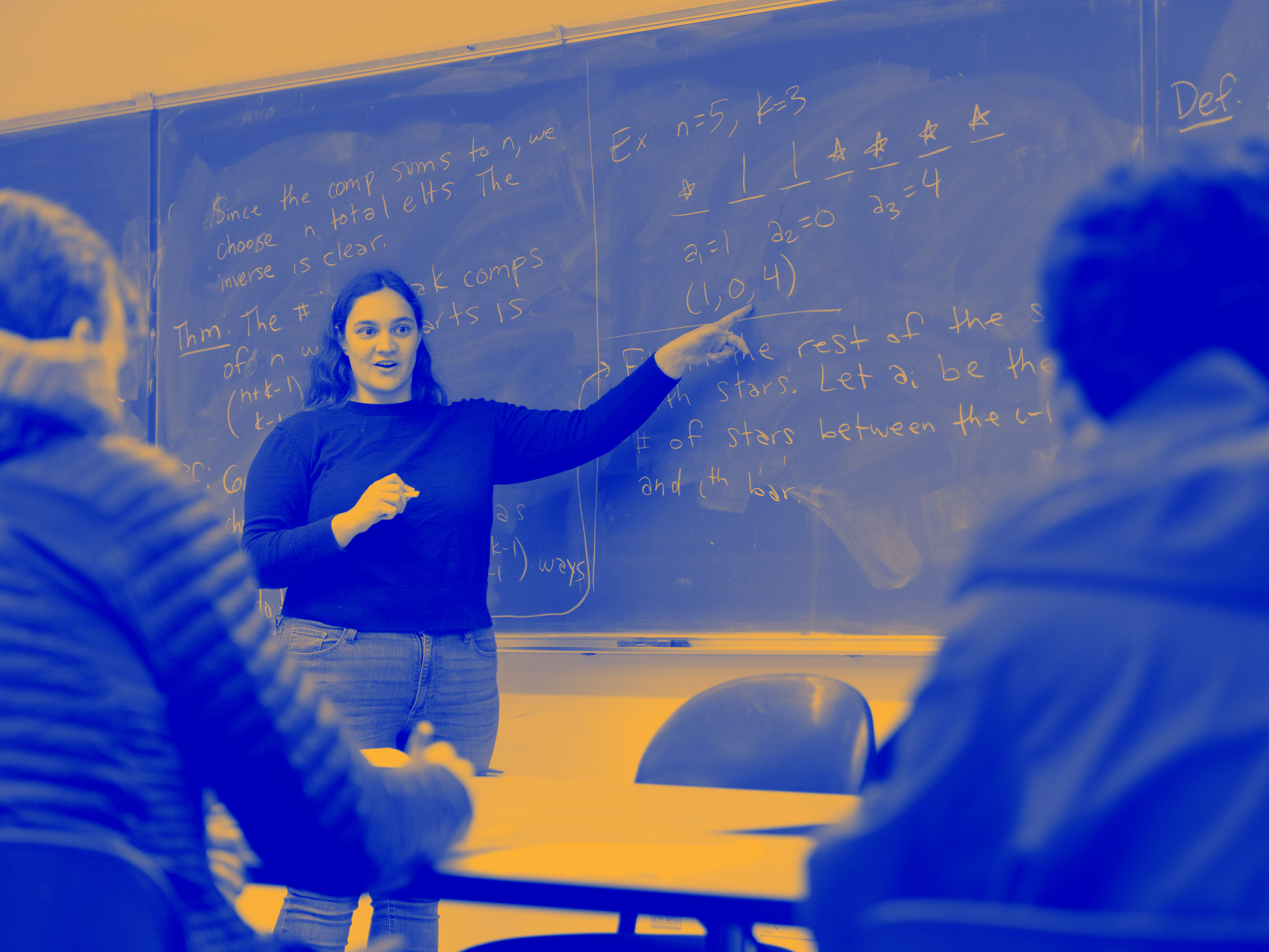 Blue and yellow tonal image of a professor pointing to a chalkboard.