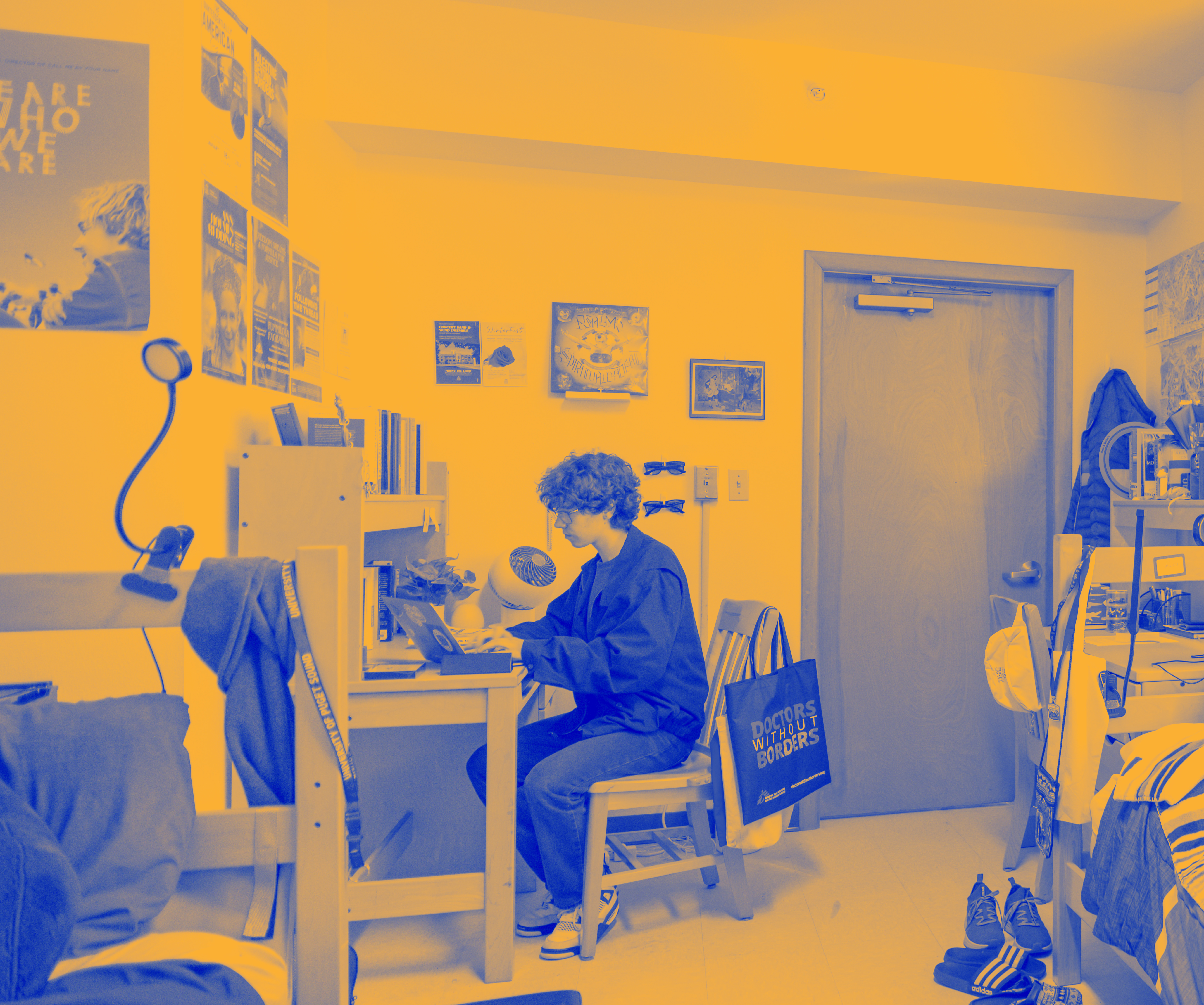 Student sitting at his desk in his room.