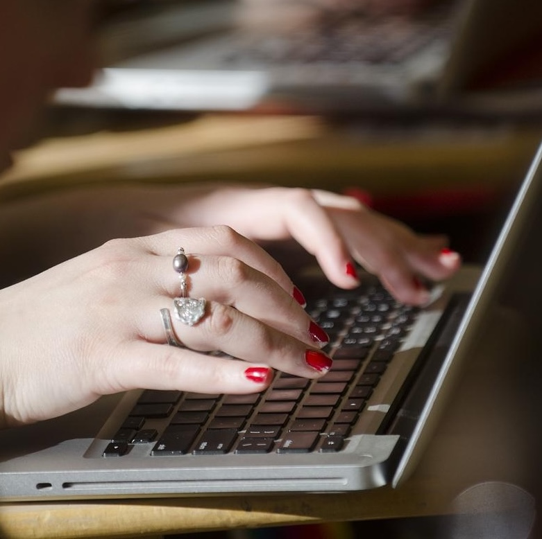 Hands typing on a laptop keyboard