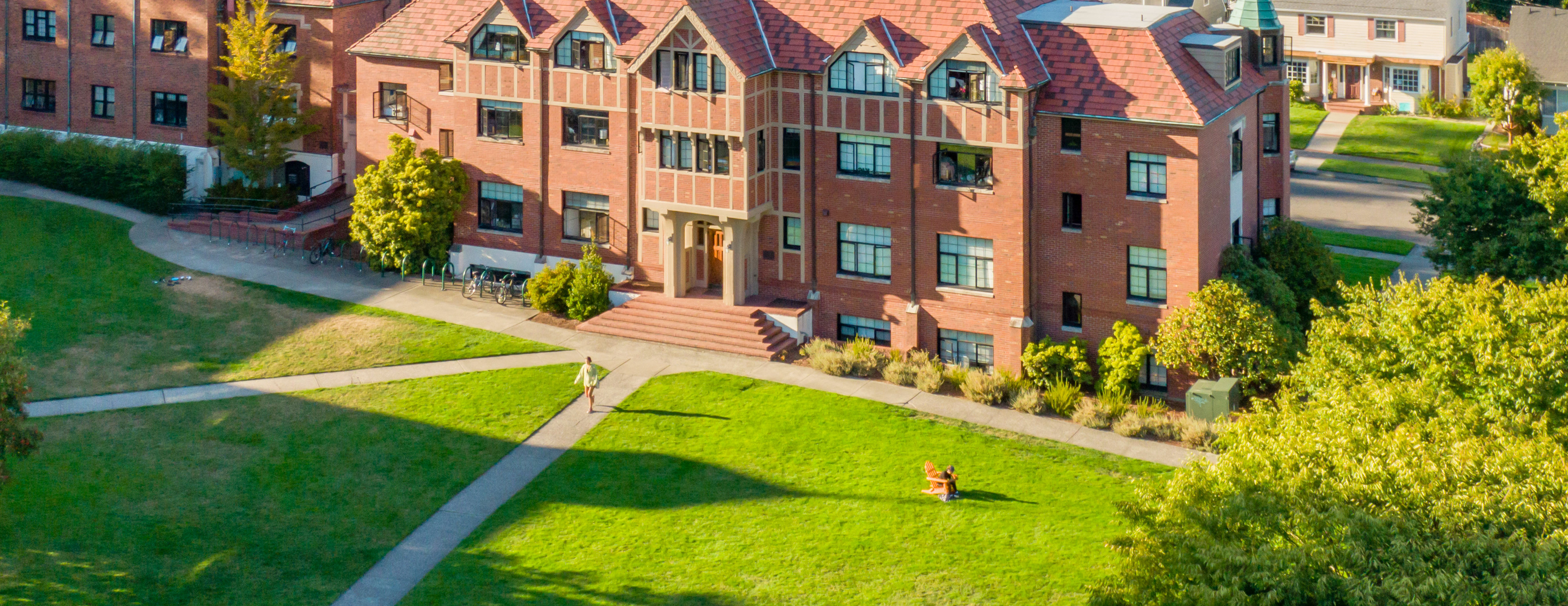 Aerial view of a red brick building and green grass.