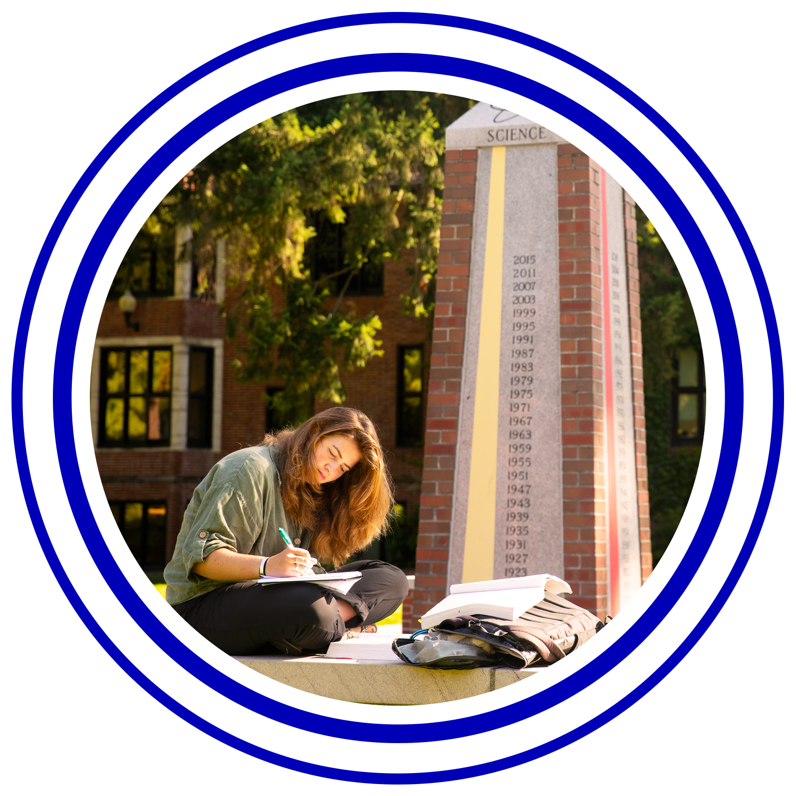 Circular image with colorful rings around it of a study sitting outside by a obelisk studying.