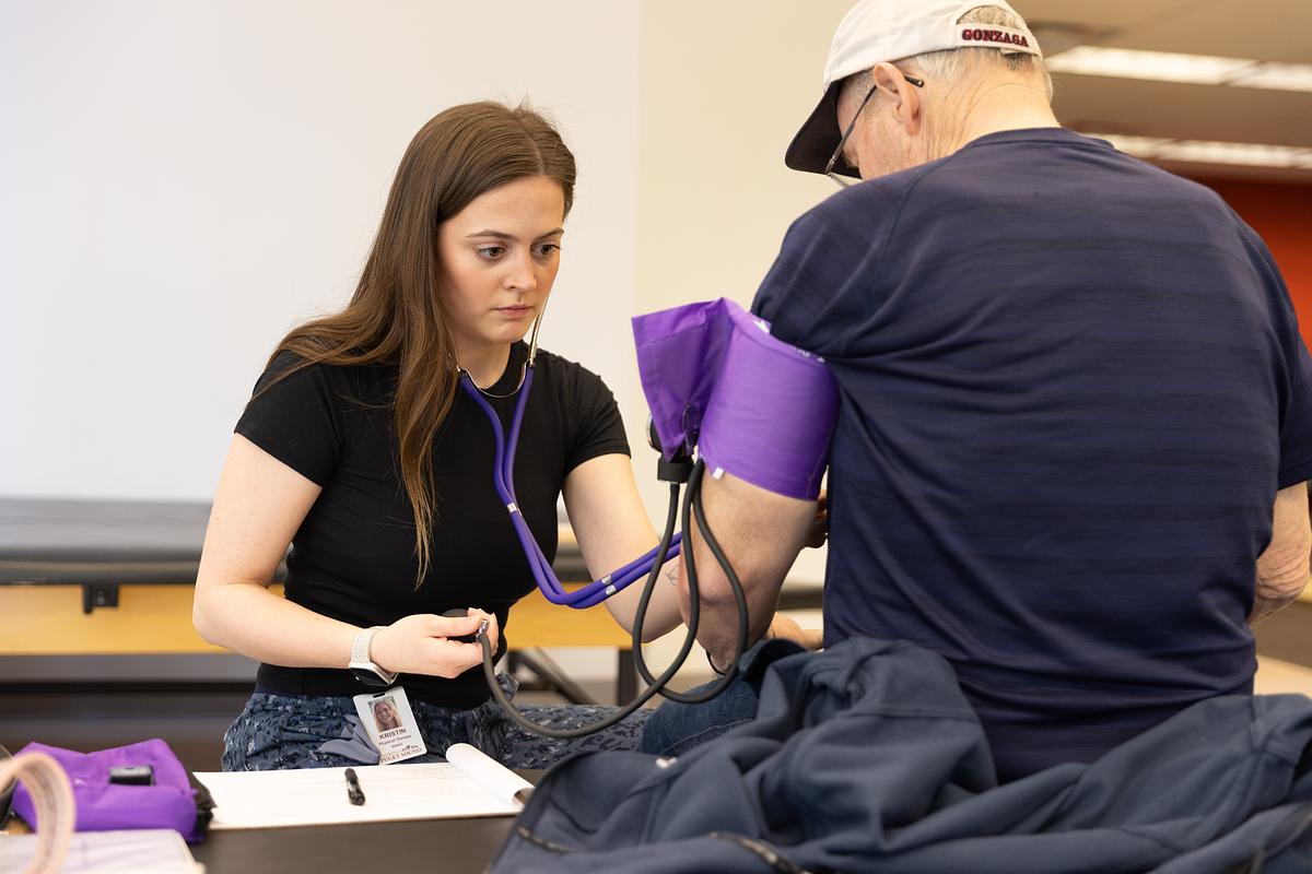 Woman checks a patients blood pressure