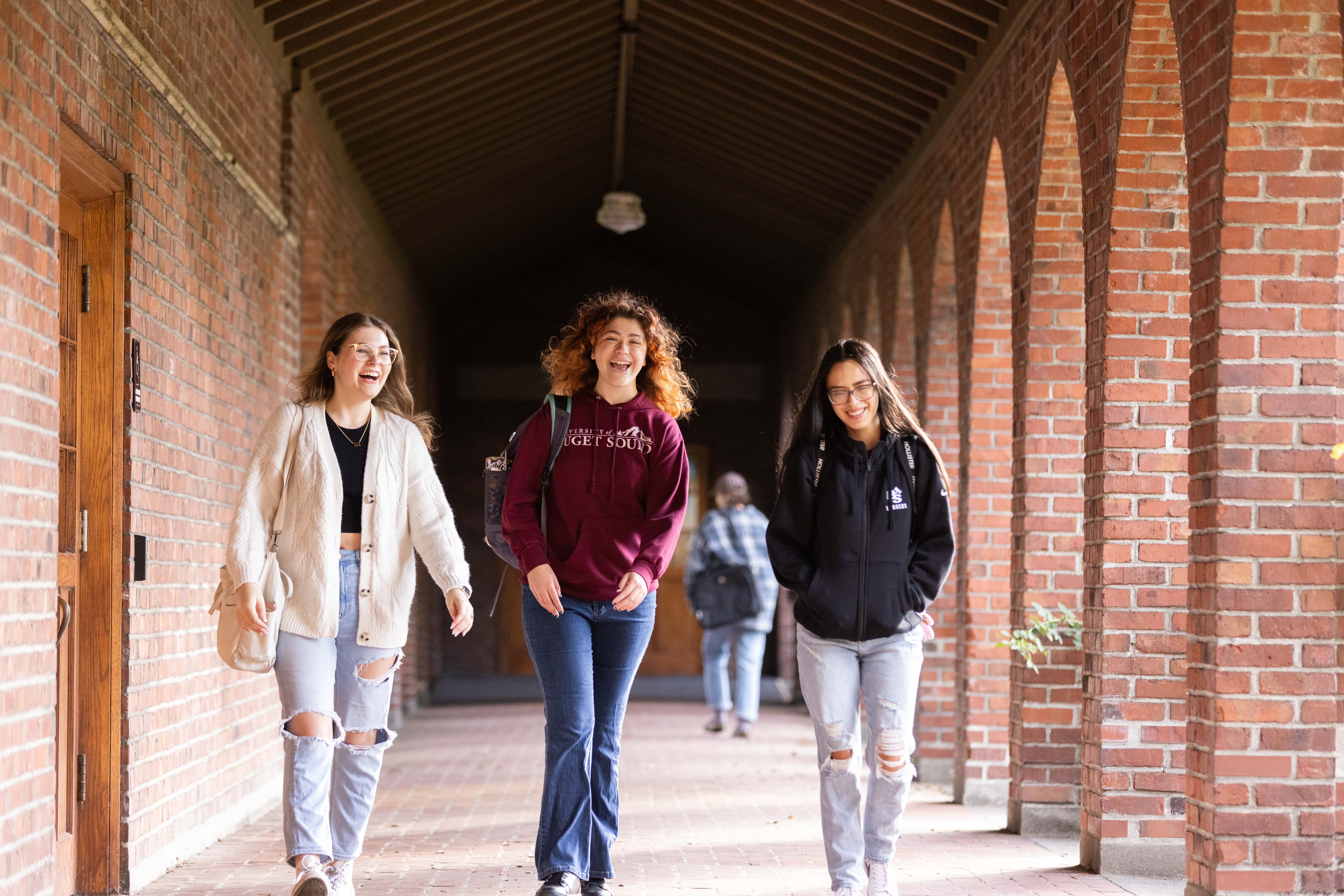 Three students chatting in the arches