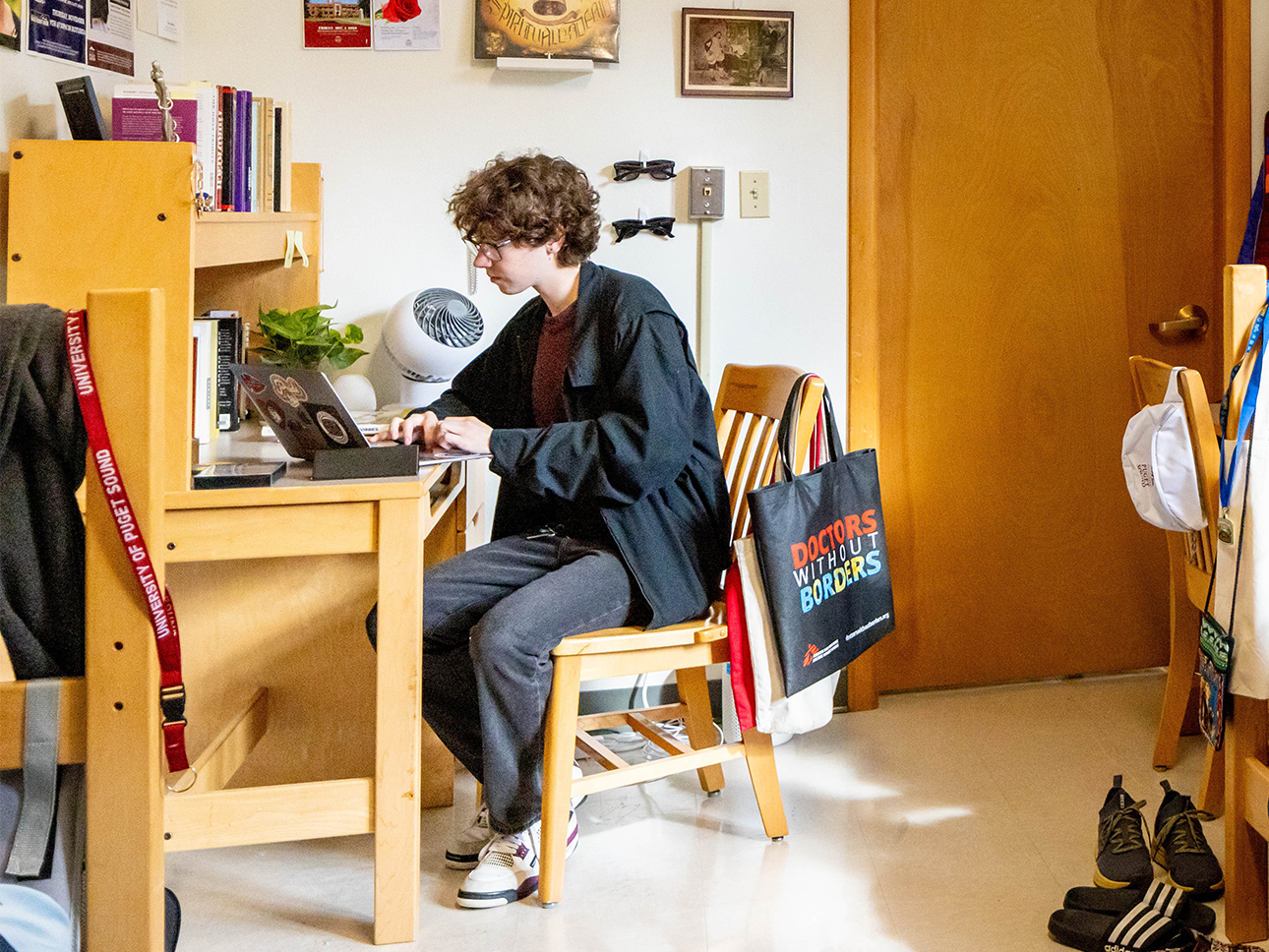 Student sitting at his desk in his room.