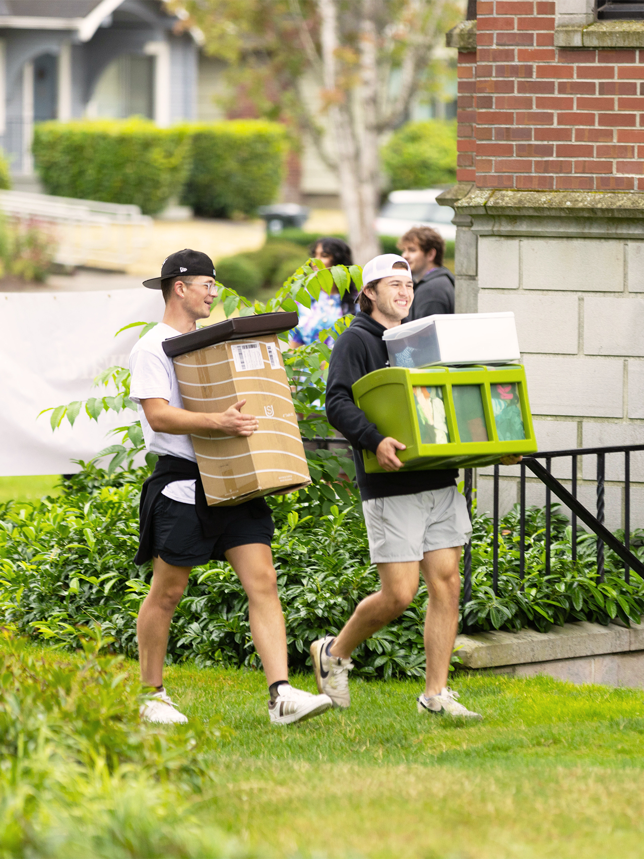 Students walking with boxes and containers for moving.