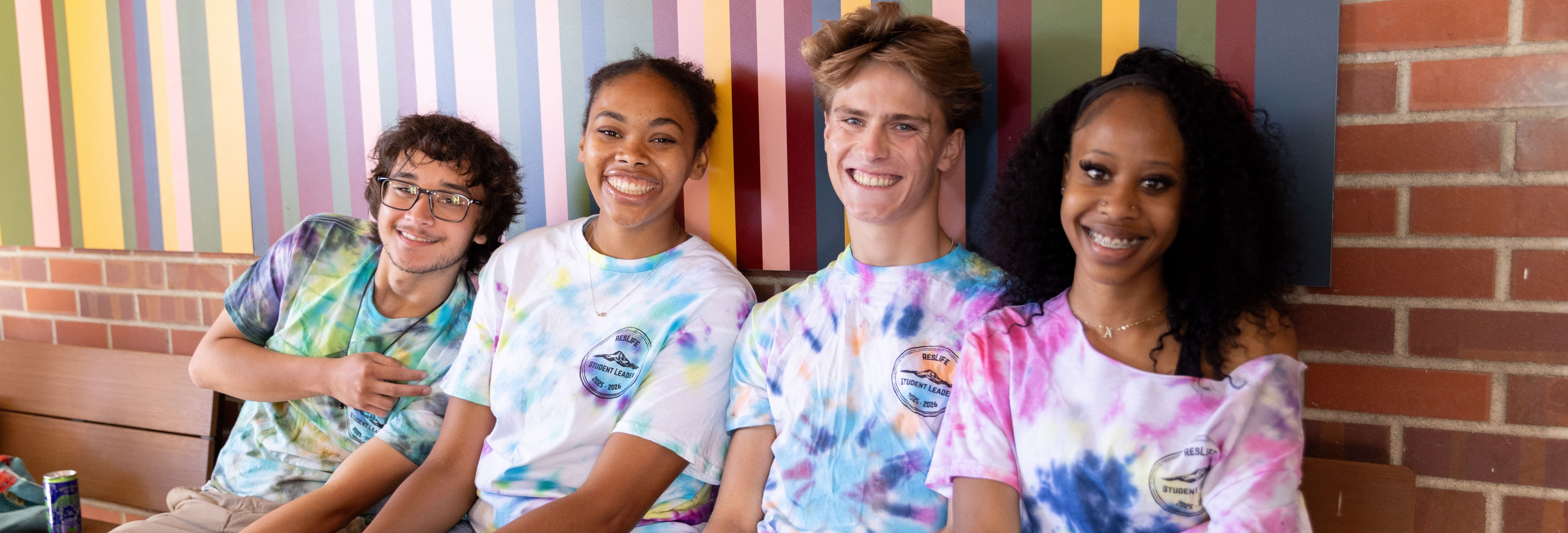 Four students in tie dye tee-shirts smiling 