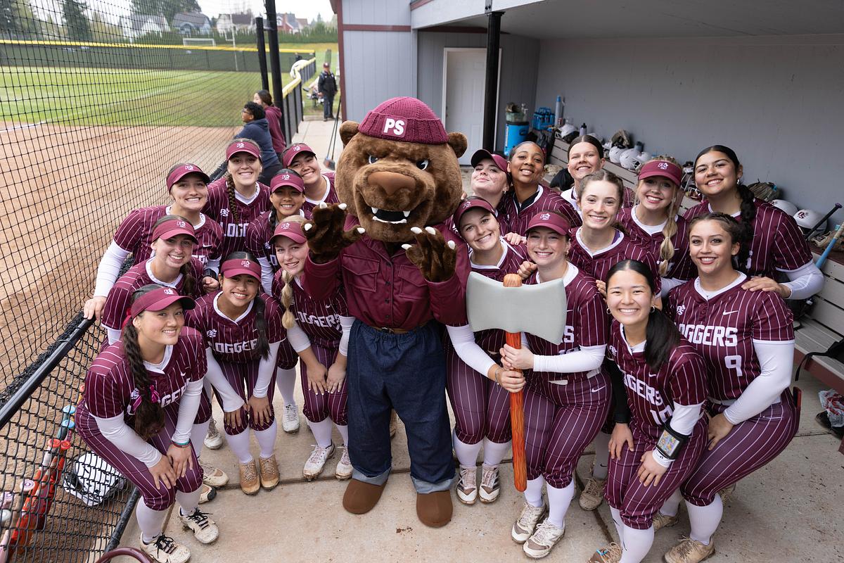 Softball team poses with Grizz in the dugout