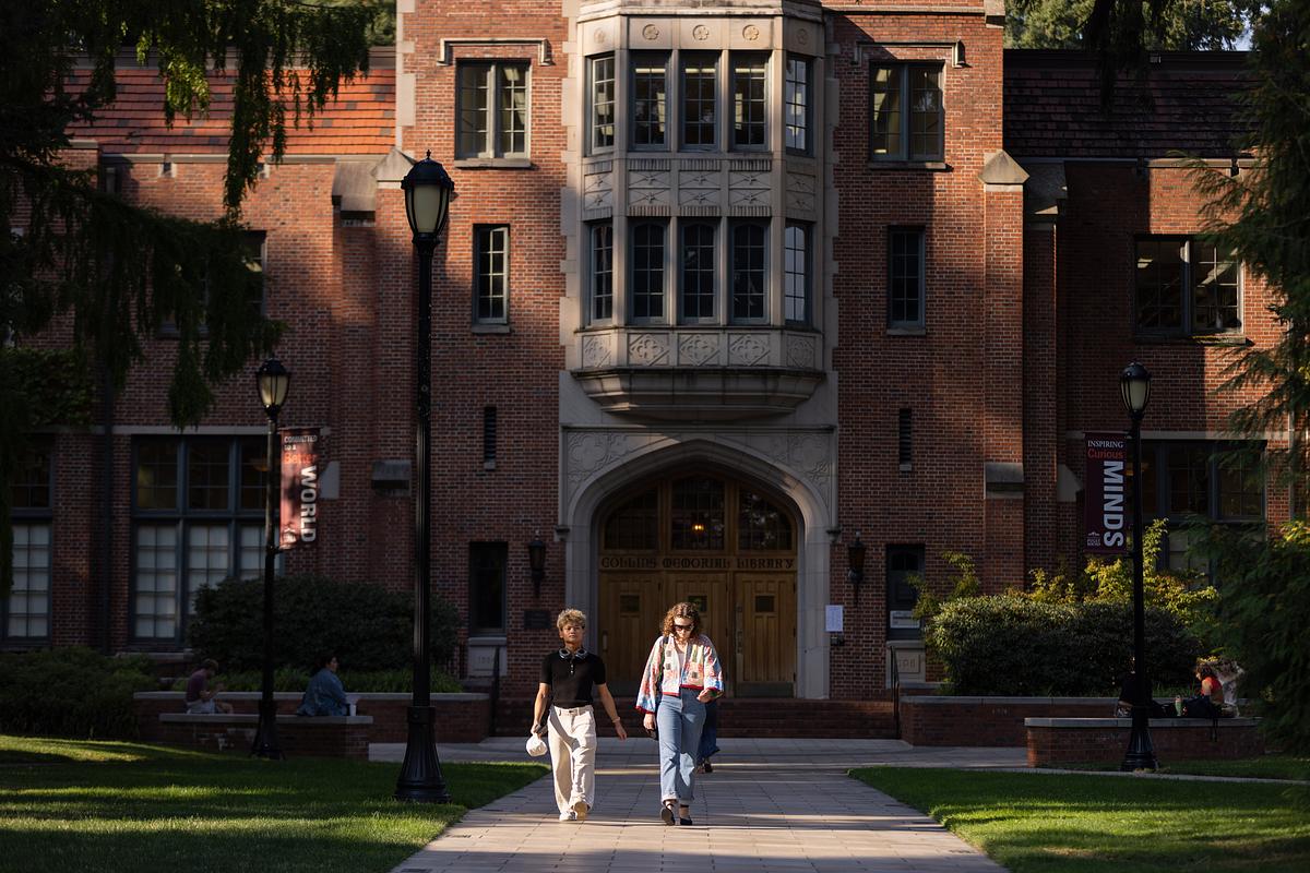 Two students walk in front of Collins Library