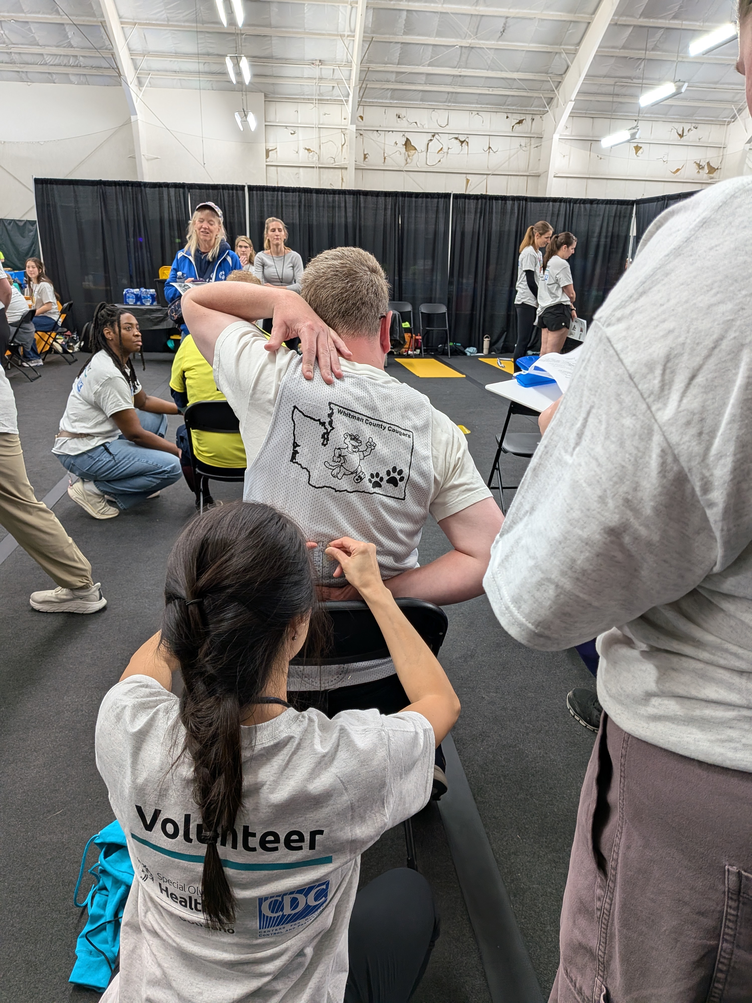 A woman measures the reach of an athlete