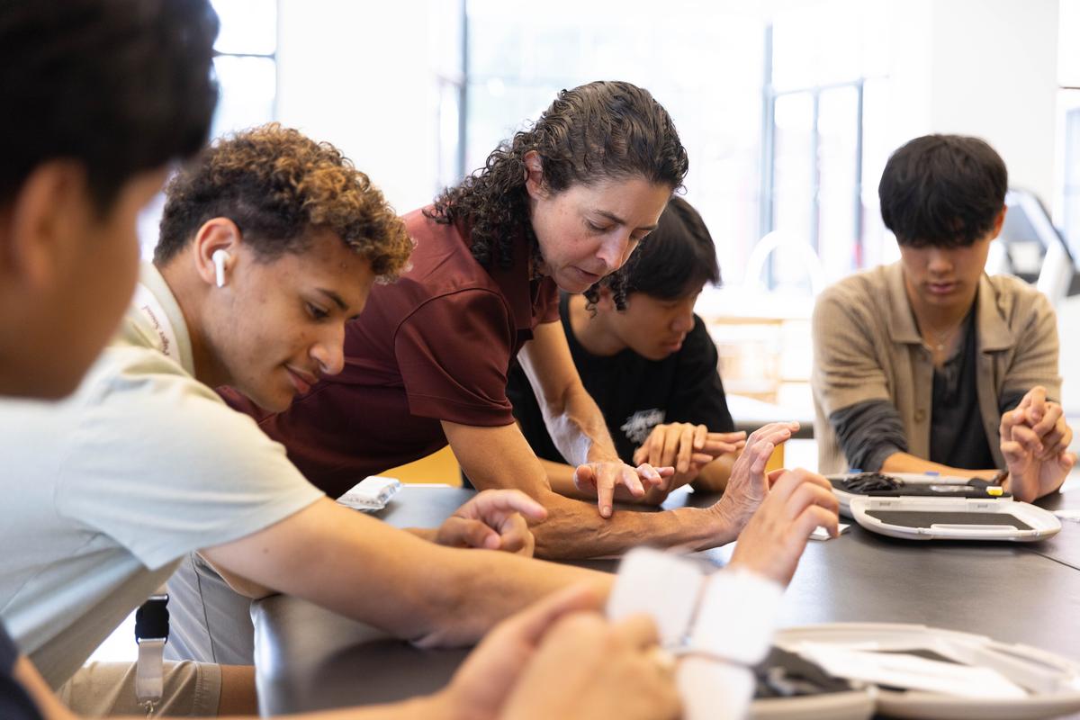 Assoc. Prof. Holly Roberts assists students in a lab. 
