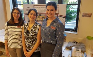 Three students beside a presentation stand