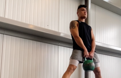 A person holding a kettlebell.