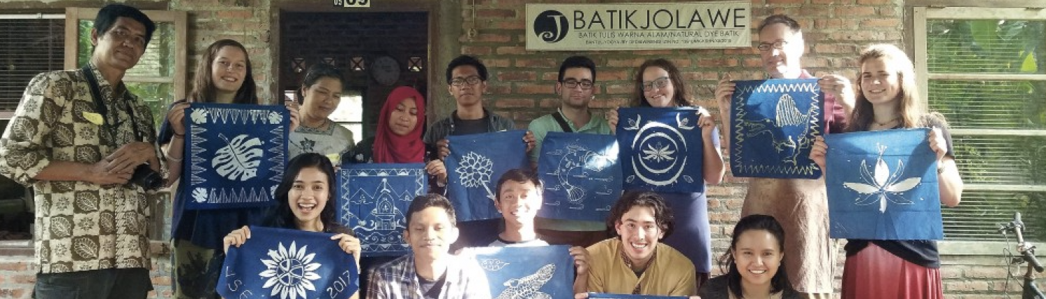 A group of people holding up Batik artwork