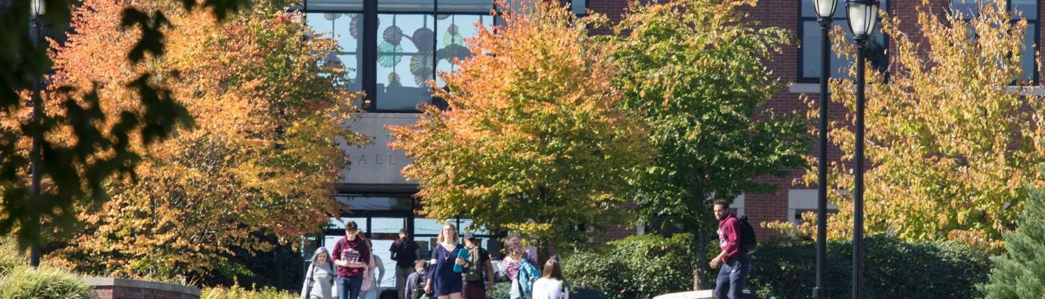 Trees and people outside Lowry Wyatt Hall during the fall season