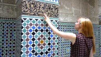 Person touching a mosaic wall