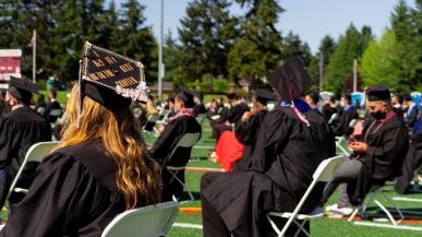 Graduates sit on Peyton Field for Commencement 2021
