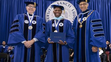 President Isiaah Crawford receives honorary degree, flanked by Joseph P. Conran (left) and Fred P. Pestello (right)