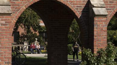 Students seen through the arches on campus.