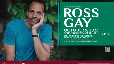 Ross Gay smiles at the camera in a blue shirt, with his face in his left hand. 