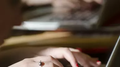 Hands typing on a laptop keyboard