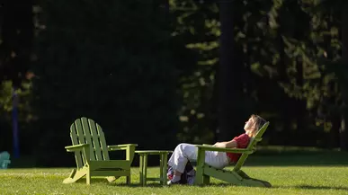 Student enjoys the sun in an Adirondack chair.