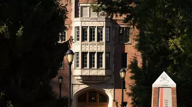 Two students walk in front of Collins Library