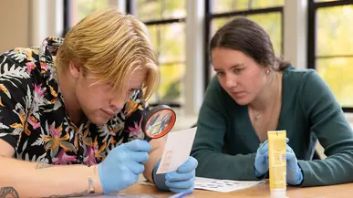 Student inspects fingerprints with a magnifying glass