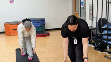 A Puget Sound student gives proper form tips while stretching. 