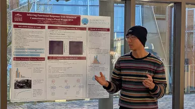 A student presents their poster. 