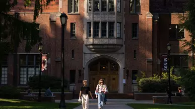 Two students walk in front of Collins Library