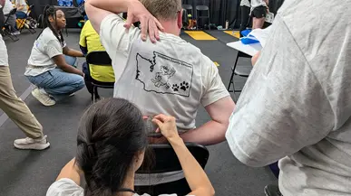 A woman measures the reach of an athlete