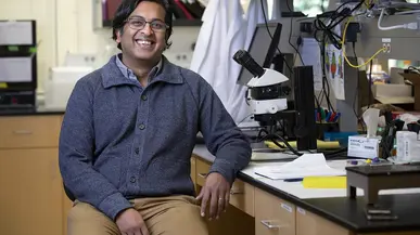 Siddharth Ramakrishnan sitting at a lab table