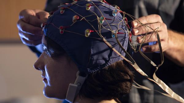 Student affixing the mechanism to study brain activity in the EEG lab.